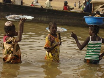 Vendors come to the boat offering food for sale en route to Timbuktu.