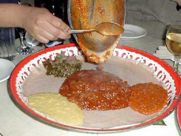 Adding goat or mutton to injera in Ethiopia.
