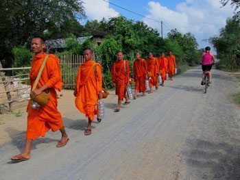 Orange-robed monks are a common roadside site in Cambodia.