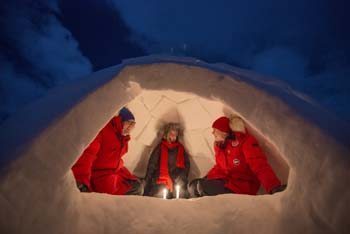 Friends huddle around a candle in an igloo they built that afternoon. Courtesy photo.
