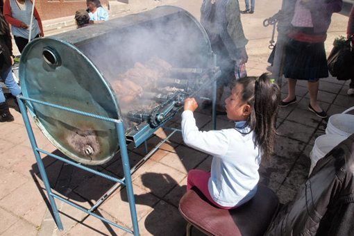 This little girl has the hardest job, turning the chicken rotisserie.