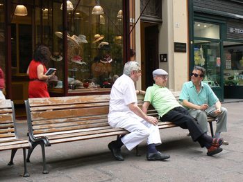 All over Bologna there are men who hang out chatting on benches. photo by Max Hartshorne.