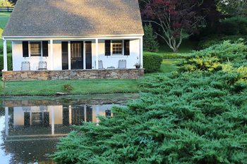 The Inn at Whitewing Farm - Our lovely cottage reflected in the pond.