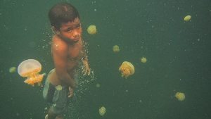 A boy swimming in the hidden lake.