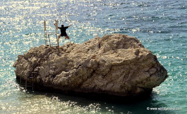 Jumping off rock into the sea.