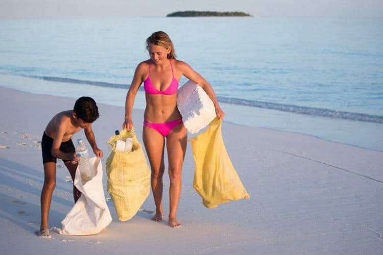 Alison is helped by a village boy cleaning up the beach.