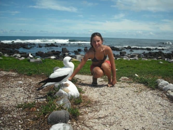 Ekaterina Golovina kneeling next to a bird, one of the four bird species that live on the island.