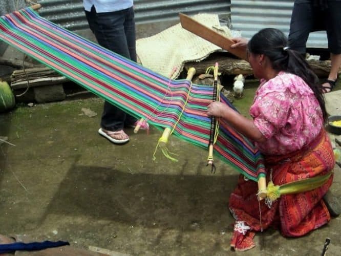 A native woman weaving with a waist loom in Xecam