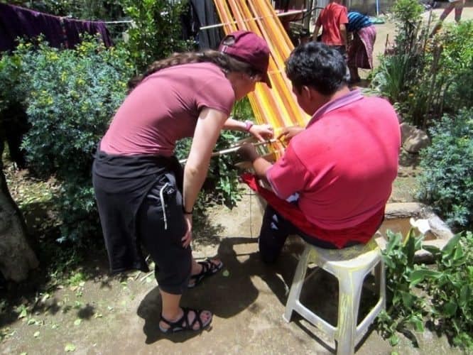 A volunteer helping a native during the Weaving Workshop. 