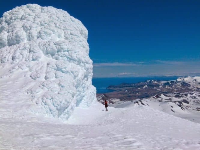 Massive snow mounds make humans seem small atop Snaefellsjokull Glacier