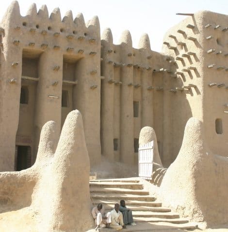 In Djenne, Mali everything is made of mud. Photographed are three boys sitting in front of the impressive mud architecture. James Dorsey Photos. 