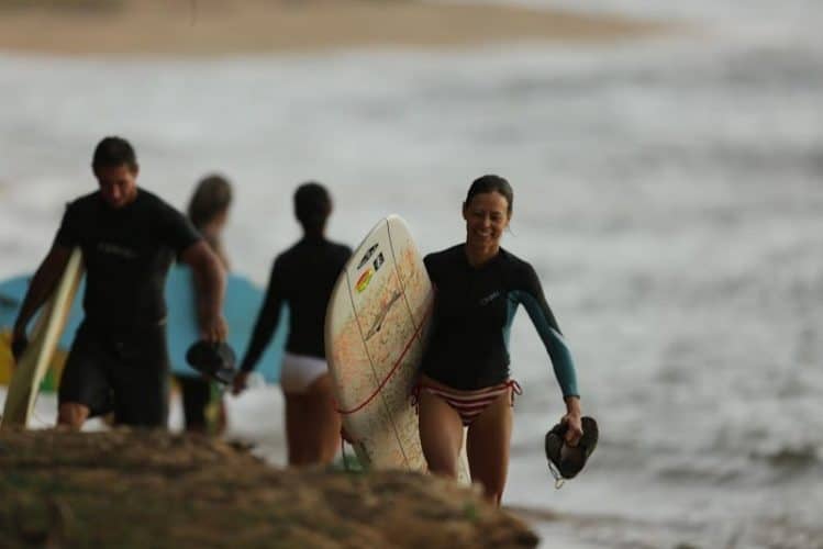 Noelle Salmi in the late afternoon after an epic surf session at Pakalas Kauai HI with Clay Wolcott Cailtin Pardo de Zela and Sarah Barton in background. Photo by Ry Cowan