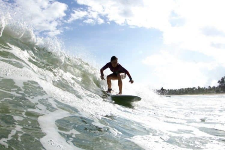Noelle Salmi rides a wave in Hanalei Bay Kauia HI. Photograph by Ry Cowan