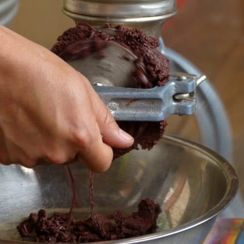 Grinding roasted cacao beans into paste