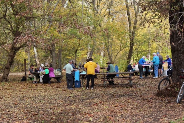 A bike group eating lunch at the picnic tables.