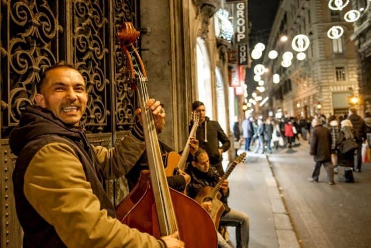 A Bulgarian string trio play Christmas carols on Via del Corso. Photo by Marina Pascucci