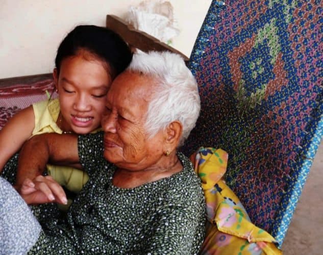 Two generations of Cambodian women sit comfortably, enjoying each other's company.