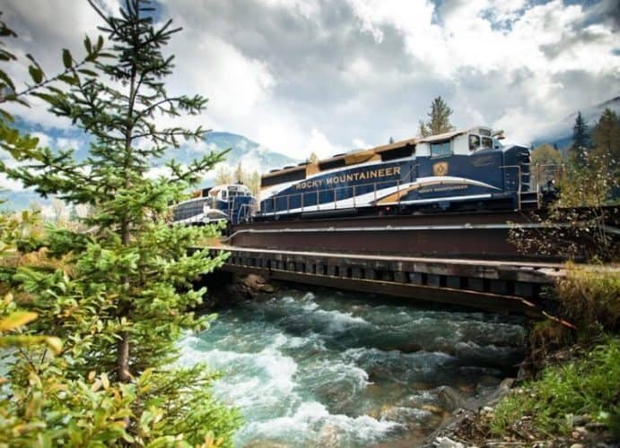 The train crosses over a stream in the Canadian Rockies.