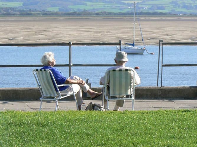 A couple enjoys the sun on the coast of Wales. Max Hartshorne photo.