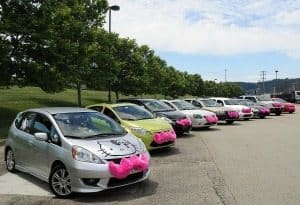 A fleet of Lyft cars with their iconic pink mustaches.