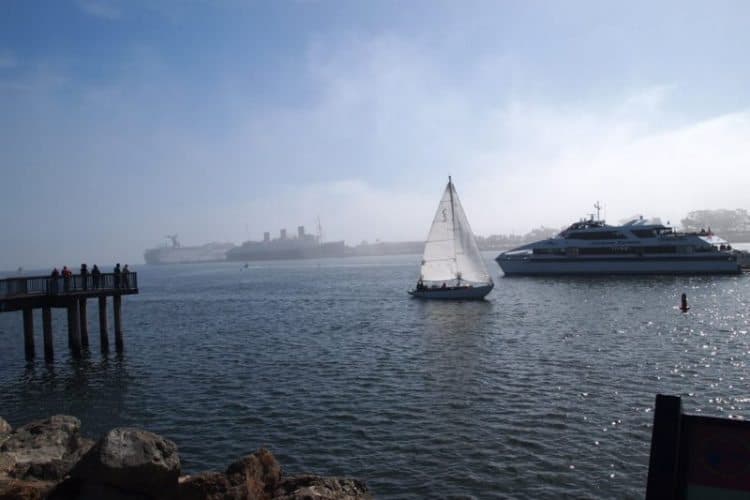 Catalina ferry with Queen Mary behind in Long Beach Rainbow Harbor.