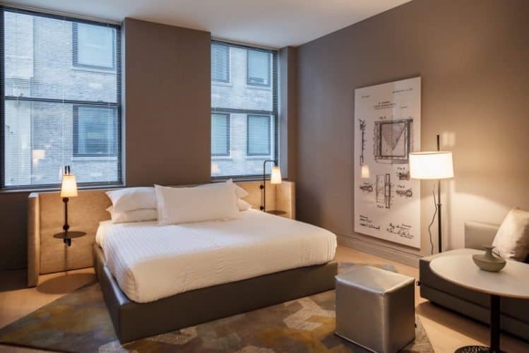 King sized bed with USB plugs handy nearby at Q&A Hotels, New York City