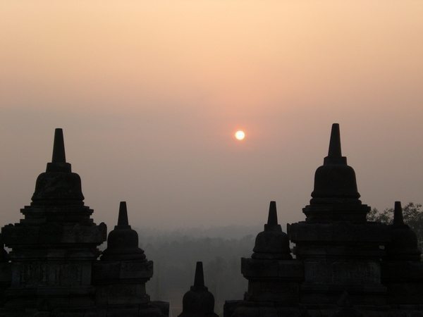 The sun makes its appearance on the horizon in Borobudur in Yogyakarta.