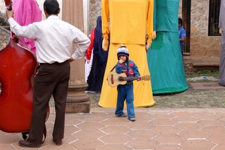 A young musician playing in the town square.