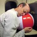 Author Joey Green sleeps on a plane with a beach ball. 