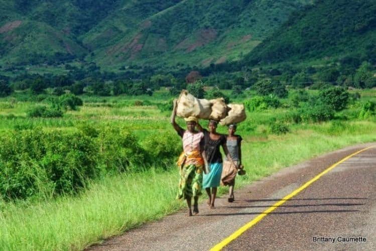 Women walking their goods along the main highway to market.