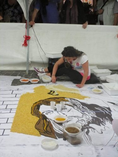 Artists work feverishly the night before the event to create the complex art to be transformed by flower petals.