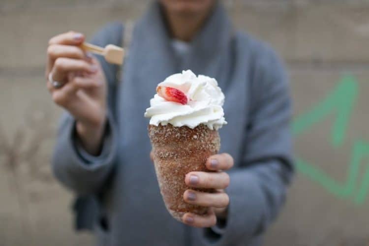 A sugar-coated Trdelnik with whipped cream and fruit topping. prague