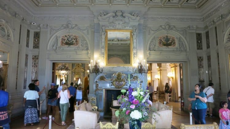 Guests stroll through the opulent rooms of Newport Mansions