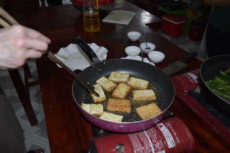 Cooking tofu during the cooking lesson.