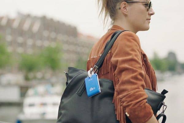 KLM Care Tag attached to a woman's purse, serving as a helpful city guide.