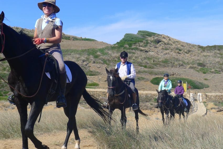 Riders on a horseback trek along Cami de Cavalls on Menorca in Spain.