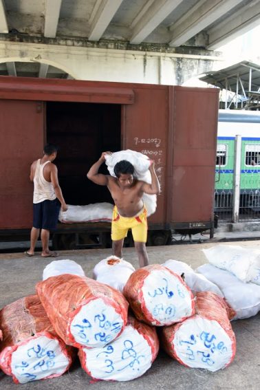 Workers unload cargo at Yangon Station. 
