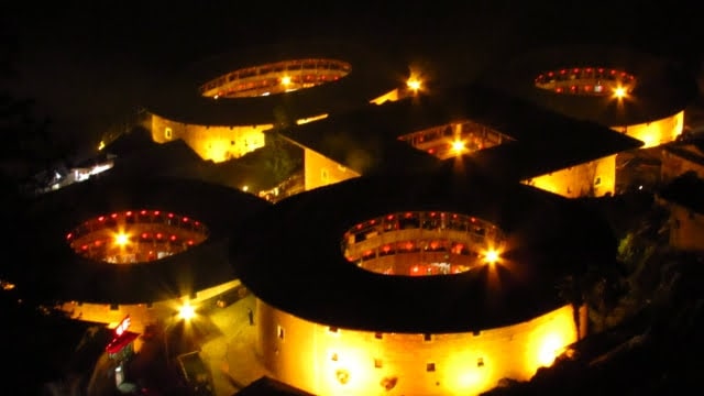 The Tianluokeng tulou cluster lit up at night during Chinese New Year.