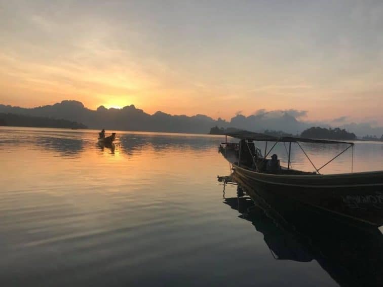 The sun rises over the mountains near Chiaw Laan Lake, Thailand. | GoNOMAD Travel