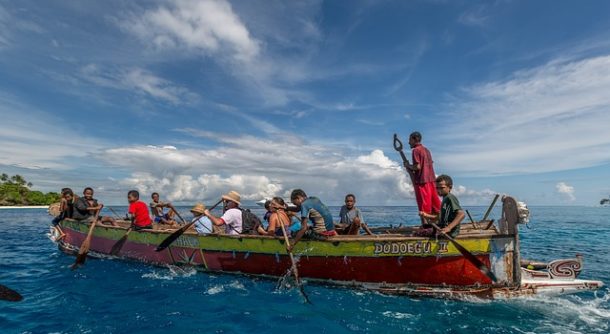 Rowing a large boat off the coast of Papua New Guinea. 
