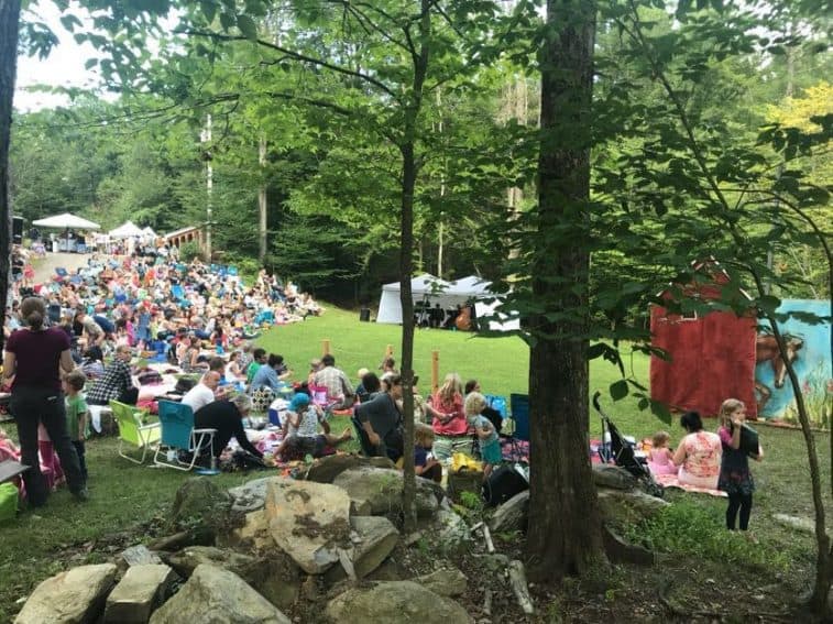 Visitors to Moonrise Farms sitting on picnic blankets and lawn chairs to view the performance.