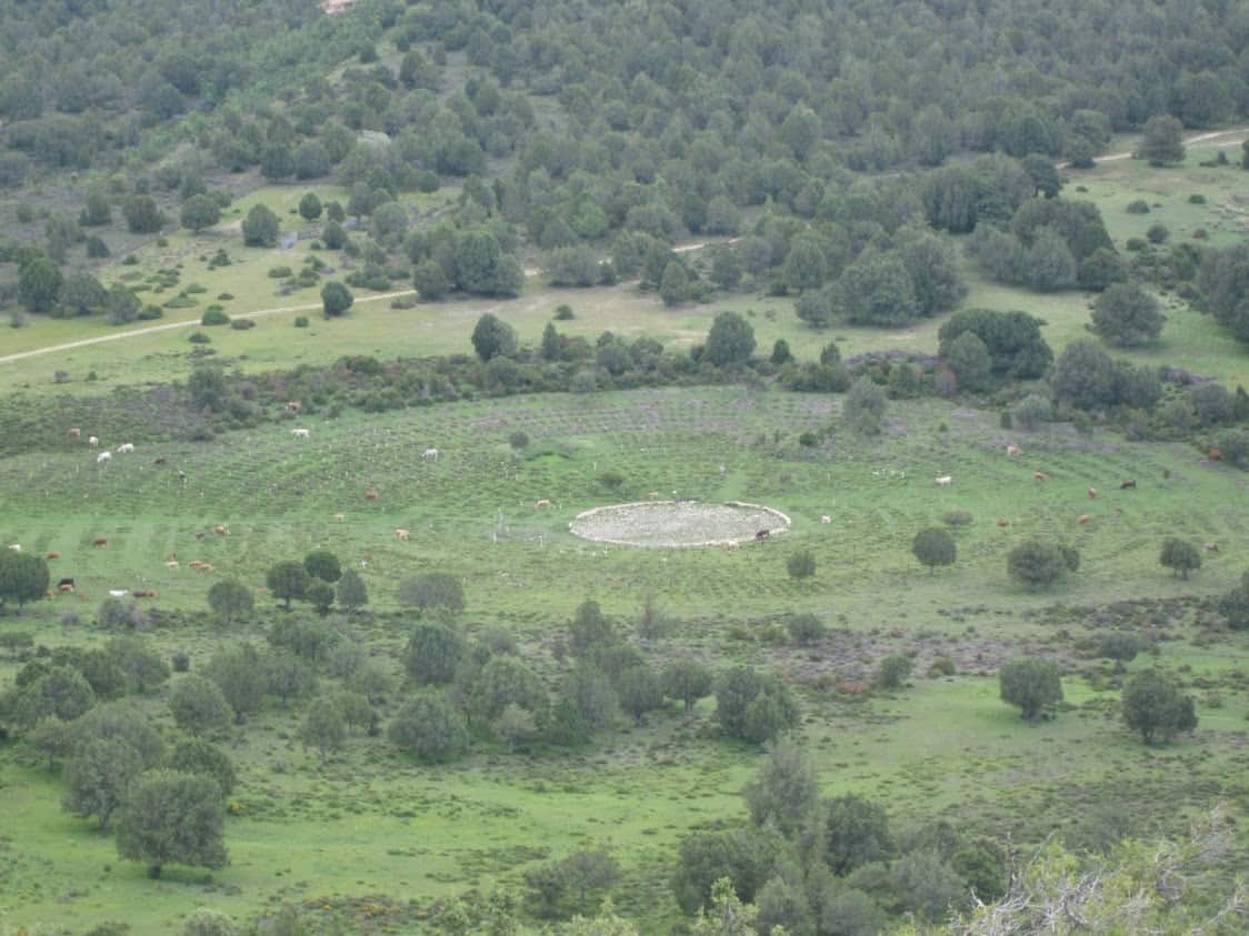 A distant view from a nearby hillside shows the concentric circle design of the fictional Sad Hill Cemetery.