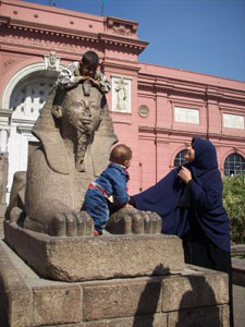 Egyptian children play atop a replica of The Great Sphinx at the entrance to the Egyptian Museum, permanent home of the King Tut Exhibit.