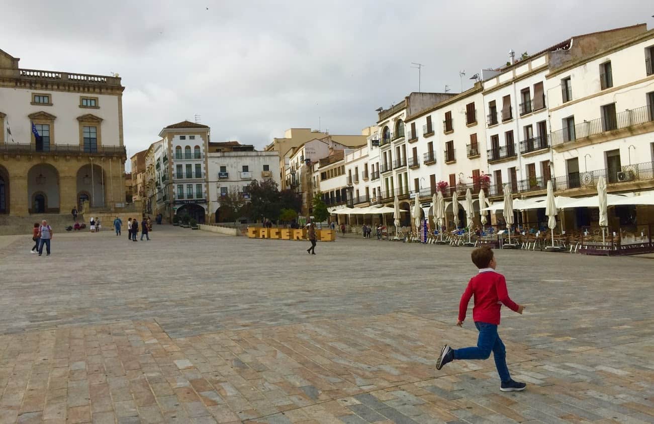 A child runs through the main plaza edging the Old Town in Cáceres.