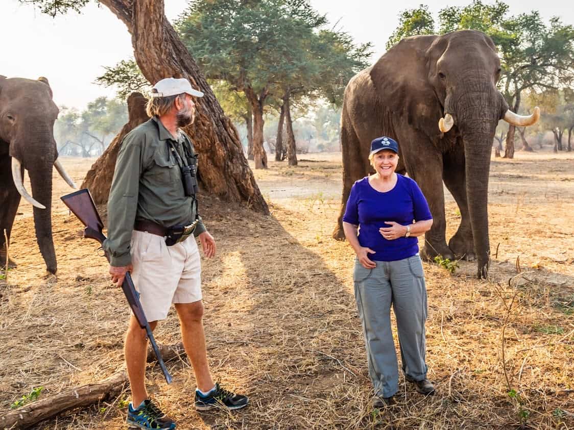 Elizabeth standing in front of a wild elephant in Mana Pools, Zimbabwe. Senior Travelers.