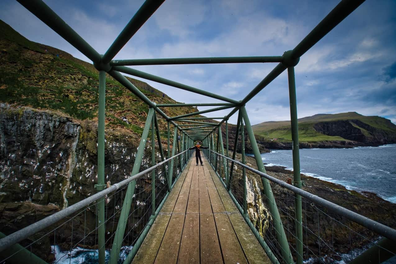 Patri crossing a bridge in Mykines, Faroe Islands.