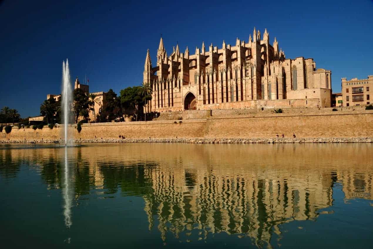 In Palma de Mallorca, the cathedral is a mix of architectural and artistic styles inside and out. The exterior and its reflection are best viewed from Parc de la Mar steps from the waterfront. 