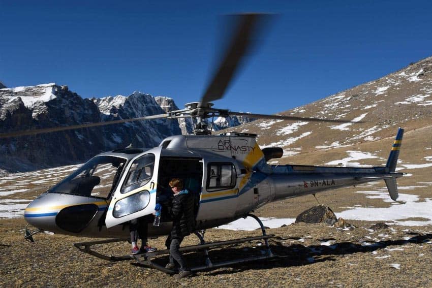 Struck with altitude sickness, Lawrence helps one of the Indian businessmen. We jumped in and out of helicopters at least 6 times, including visiting an alpine restaurant for breakfast, ($25 US) so the much wanted front seat was shared.