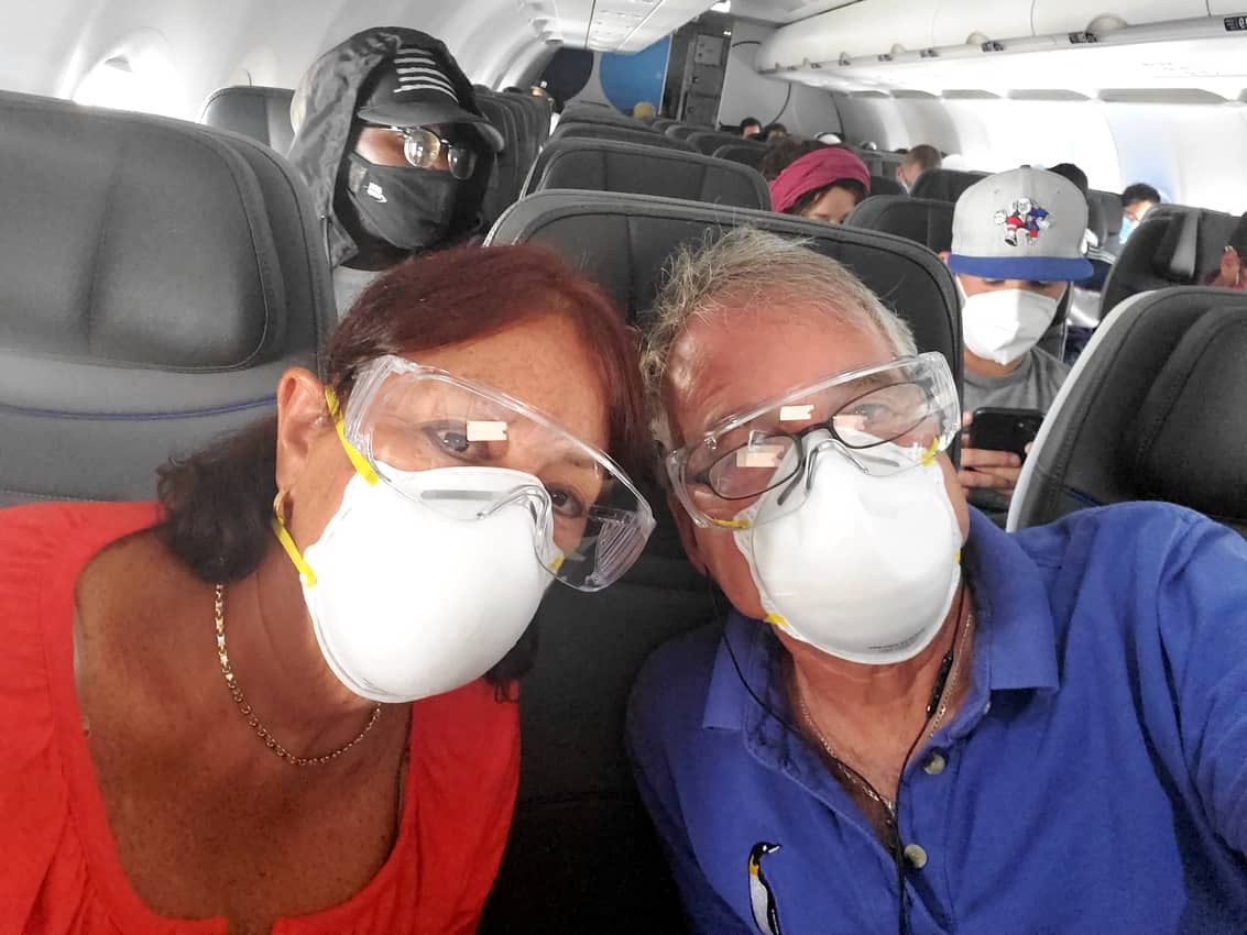 Tab and Maureen Hauser on Jet Blue wearing a mask and eye protection. 
