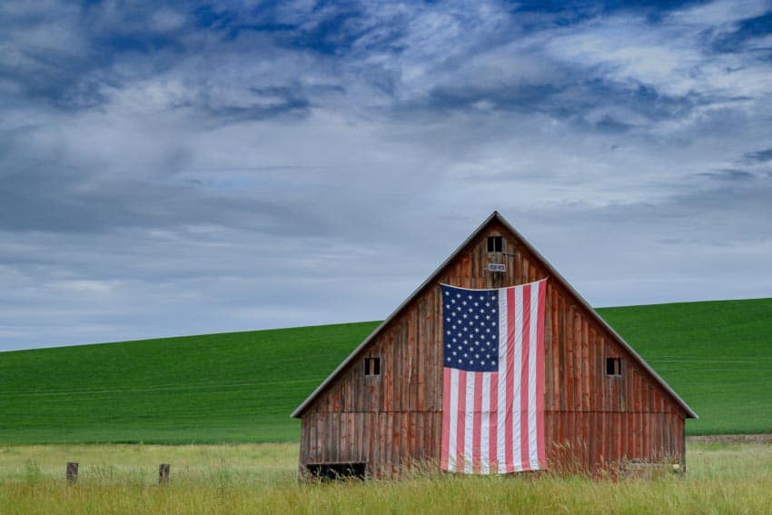 The Horn School red gable barn is adorned with the American flag.